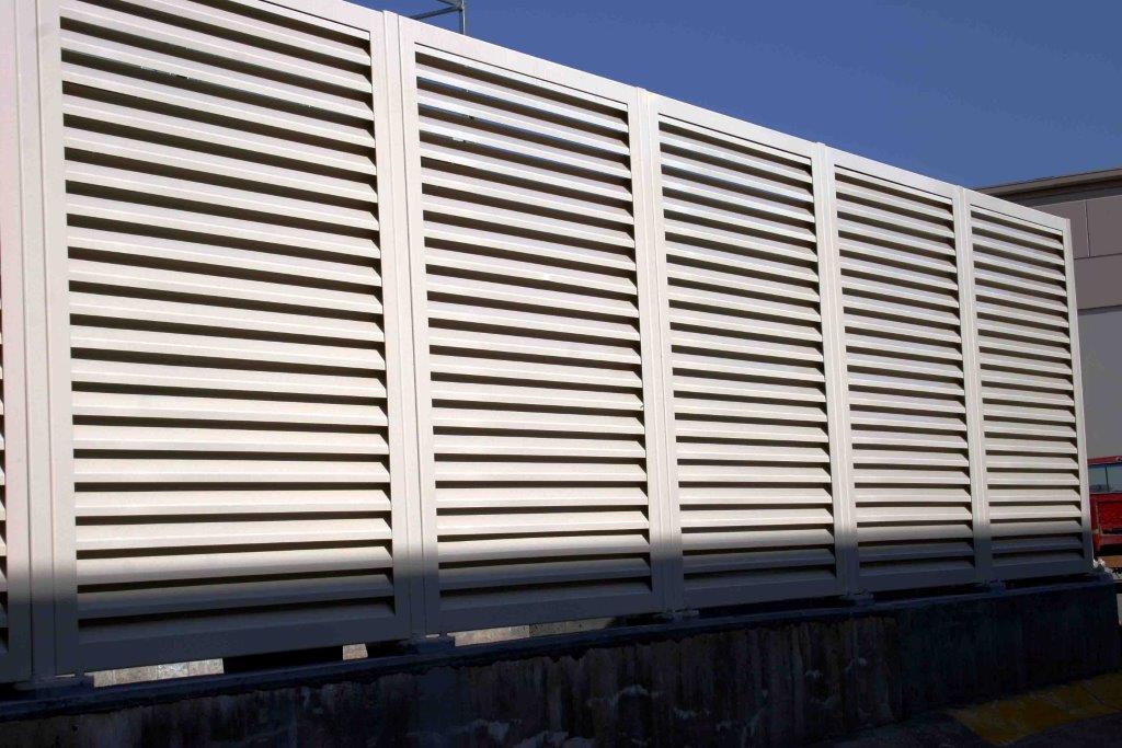 Louvered equipment screening PalmSHIELD Louvers. Steel vertical louver screen system. architectural mechanical screening screen louvered semi private private solid staggered board on board shadow box alternating ametco barnett and bates industrial louvers rooftop louvers beta orsogrill omega chillers generators truck wells outside storage condensors rooftop equipment patios trash dumpsters transformers HVAC courtyards pool equipment fence aluminum galvanized steel degree of openness direct visibility standalone wall louvers