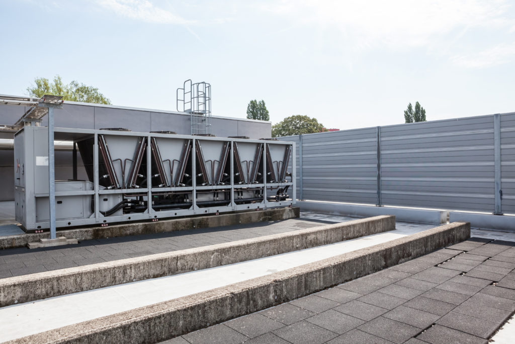 Image of rooftop-mounted air conditioning equipment surrounded by rooftop screen walls.